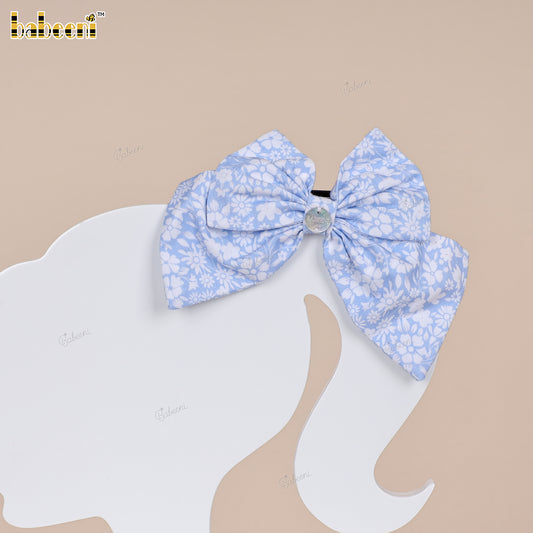 Blue floral fabric bow with glossy center accent. - HB183